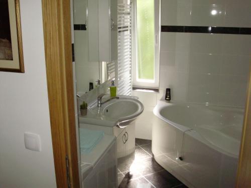 ein weißes Badezimmer mit einer Badewanne, einem Waschbecken und einer Badewanne in der Unterkunft Apartment Maximilian-free parking!!! in Zagreb