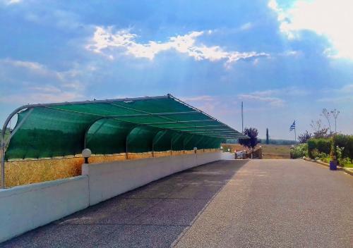 a building with a green roof on the side of a road at S4Sani in Sani Beach