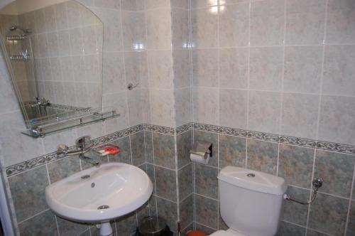 La salle de bains est pourvue de toilettes blanches et d'un lavabo. dans l'établissement Family Hotel Biju, à Tryavna