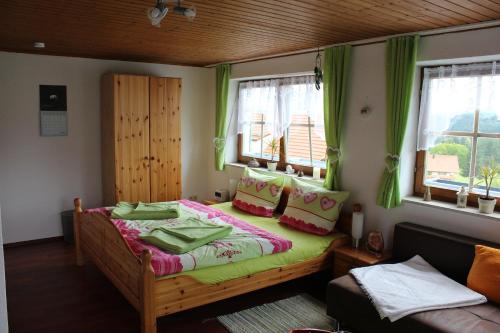 ザンクト・オスヴァルトにあるHaus Sonnenbergのベッドルーム1室(緑のカーテン付きの木製ベッド1台付)