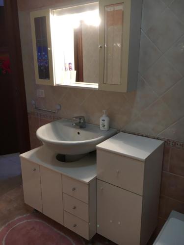 y baño con lavabo y espejo. en Apartment in Residence King's Bay en Fano