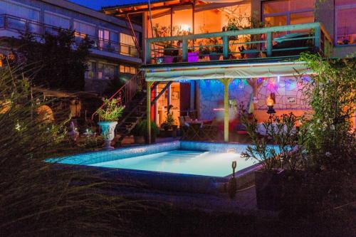 - une piscine en face d'une maison la nuit dans l'établissement Villa Sonnenschein, à Hévíz