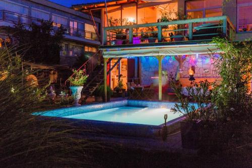 a swimming pool in front of a house at night at Villa Sonnenschein in Hévíz