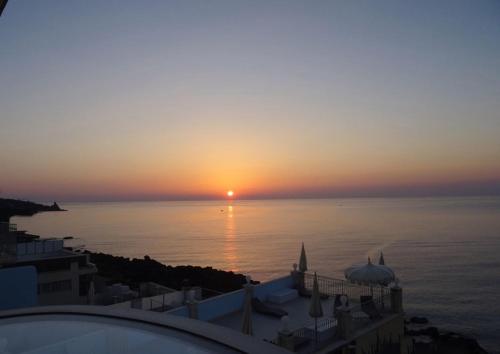 a sunset over the water with the sun setting over the ocean at B&B Acireale - Il Cavalluccio Marino Fronte Mare in Acireale