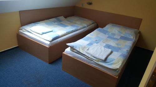 two beds in a small room with towels on them at Lehár panzió in Komárno