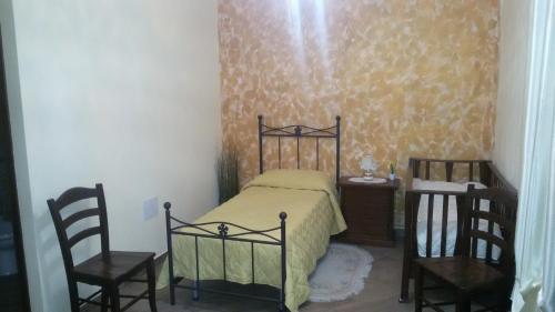 a bedroom with a bed with two chairs and a table at Agriturismo la stragola in Nicosia
