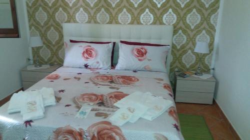 Un dormitorio con una cama con rosas. en Crisam, en Sabaudia
