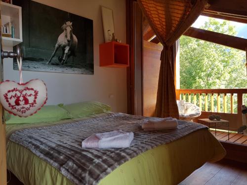 a bedroom with a bed with a horse picture on the wall at Arpege Des Neiges in Sainte-Foy-Tarentaise