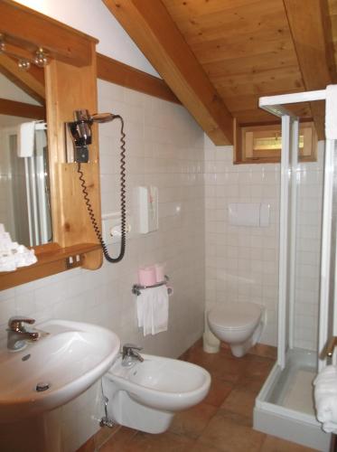 a bathroom with a sink and a toilet at Hotel da Beppe Sello in Cortina dʼAmpezzo