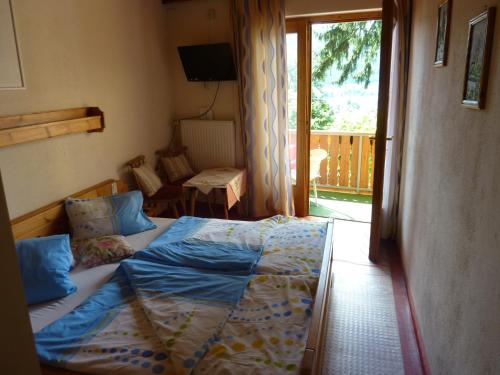 a bedroom with a bed and a balcony at Frühstückspension Blasge in Bodensdorf
