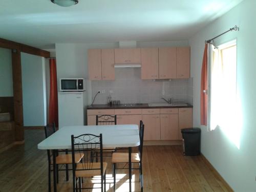 une cuisine avec une table et des chaises dans une pièce dans l'établissement le bon air est dans le pre, à Champagnac