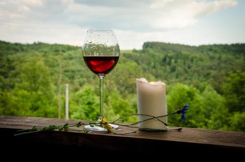 een glas wijn en een kaars op een tafel bij Na koncu swiata in Dubiecko