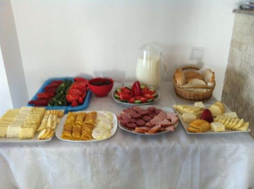 a table topped with plates of different types of food at Pensiunea Drumul Voievozilor in Arefu