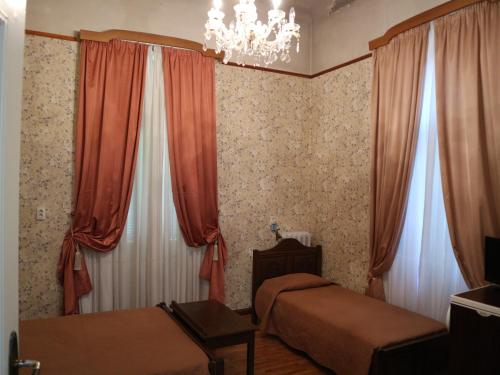 a bedroom with two beds and a chandelier at Acropolis House in Athens