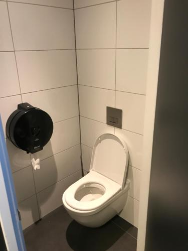 La salle de bains est pourvue de toilettes et d'un distributeur de papier toilette. dans l'établissement Amsterdam Red Light Bed & Breakfast, à Amsterdam