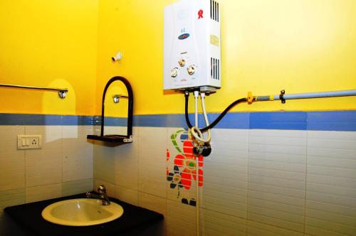 a bathroom with a sink and a soap dispenser at Akashadeepa Homestay in Madikeri