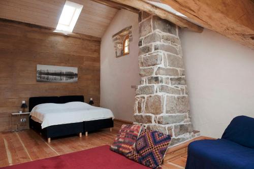 a bedroom with a bed and a stone wall at Pas de Deux in Sainte-Marie-en-Chanois