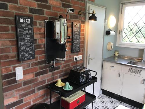 una cocina con una pared de ladrillo y una mesa en Villa Heidi, en Solingen