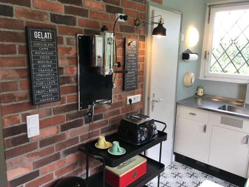 a kitchen with a brick wall and a table at Villa Heidi in Solingen