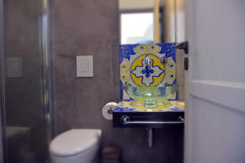 a bathroom with a toilet and a vase on a door at Dammuso SOLMAR in Pantelleria
