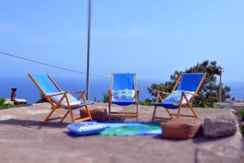 a group of three chairs sitting on a patio at Dammuso SOLMAR in Pantelleria