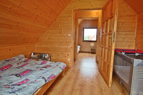 a bedroom with a bed in a wooden cabin at Magija Bałtyku in Sarbinowo