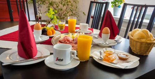 a table with a breakfast of eggs and bread and orange juice at Gasthof Silberner Hirsch in Güssing