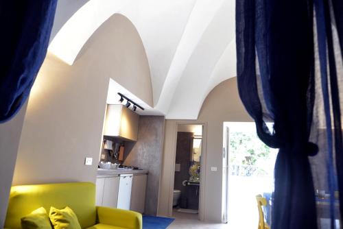 a living room with a yellow couch and a window at Dammuso SOLMAR in Pantelleria