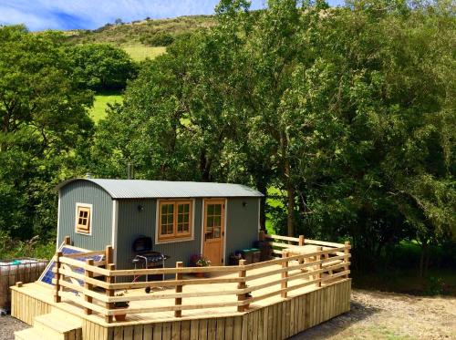 a tiny house sitting on a wooden fence at Mid Wales Luxury Huts in Darowen