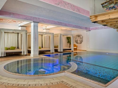 a large swimming pool in a room with a large pool at Hotel Berghof in Zermatt