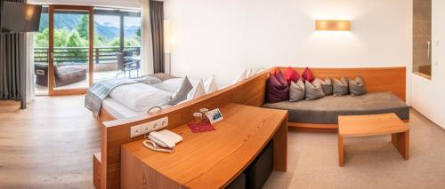 a room with a bed and a desk in a room at La Casies Mountain Hotel in Santa Maddalena in Casies