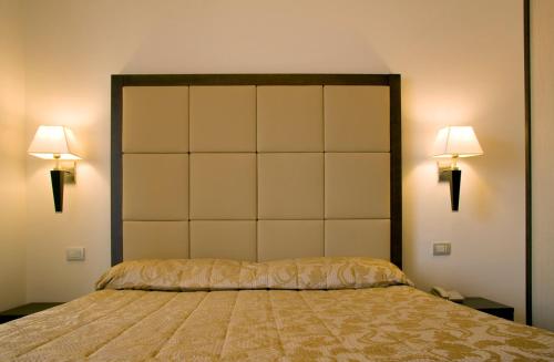 a bedroom with a large bed with two lights on it at Hotel Bahia in San Benedetto del Tronto