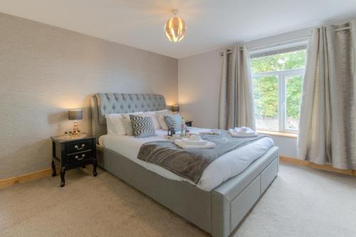 a bedroom with a large bed and a window at Beach Breeze Cottage - 3 Bed in Caister-on-Sea