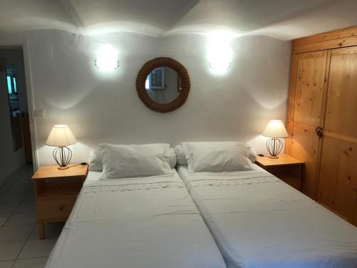 邦多勒的住宿－Le Belvedere，一间卧室设有两张床,墙上设有一面镜子