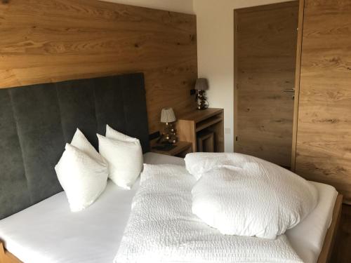 a bed with white sheets and pillows on it at Balgnerhof in Laion