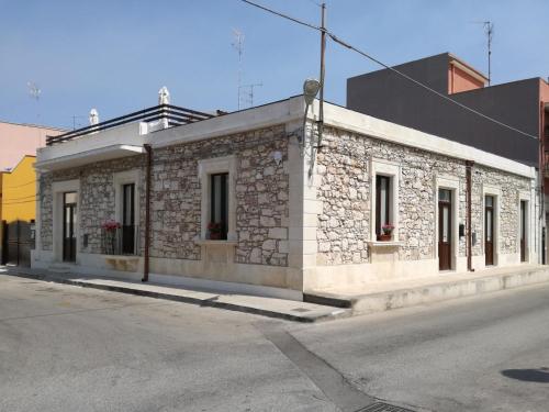 un edificio de piedra al lado de una calle en La casa di Bice, en Cassibile