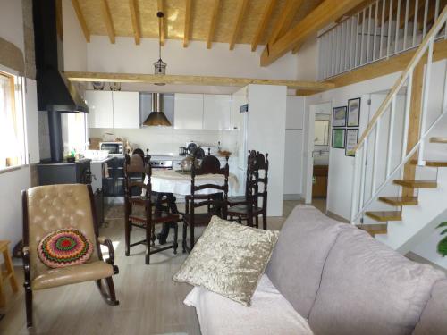 ein Wohnzimmer mit einem Sofa und Stühlen sowie eine Küche in der Unterkunft Casa Retiro de Lisei in Penalva do Castelo