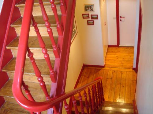 a wooden staircase with red railings in a house at B&B Brigitte & Alain in Brussels