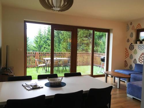 a living room with a table and chairs and a patio at Apartmány Pinie Lipno in Lipno nad Vltavou