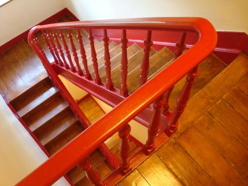a red railing on a staircase with wooden floors at B&B Brigitte & Alain in Brussels