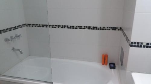 Un baño con ducha con puerta de cristal. en Veluvi, en Puerto Madryn