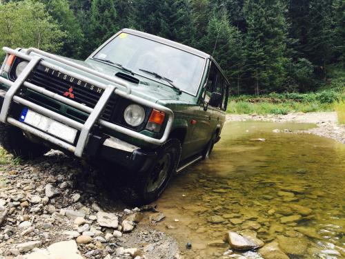 a green jeep parked in a stream of water at Tarninowe Wzgórze in Kunkowa