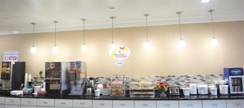 a counter in a store with lights hanging above it at Super 8 by Wyndham Galveston in Galveston