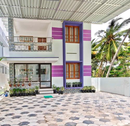 a house with a purple and white facade at Rams Guest House Near Lulu Mall in Trivandrum