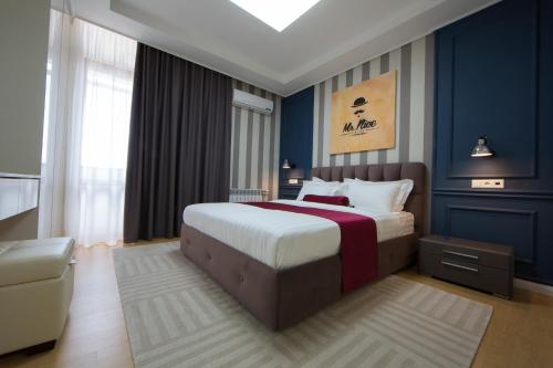1 dormitorio con 1 cama grande y paredes azules en Mr Nice Apartments, Highvill-Astana, en Astana
