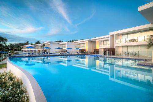 einem großen Pool mit blauem Wasser vor einem Gebäude in der Unterkunft Pool Resort Port Douglas in Port Douglas