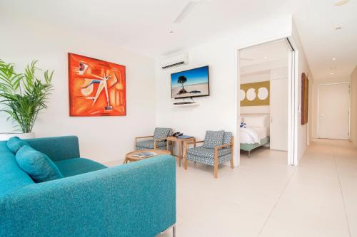 a living room with a blue couch and a bedroom at Pool Resort Port Douglas in Port Douglas