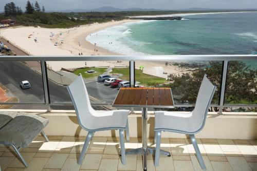 a balcony with a table and chairs and a beach at Beachpoint Unit 501 in Forster
