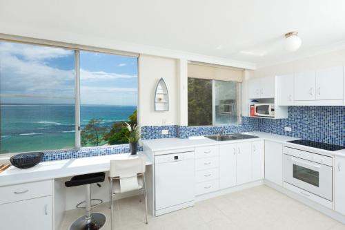 a white kitchen with a view of the ocean at Beachpoint Unit 501 in Forster