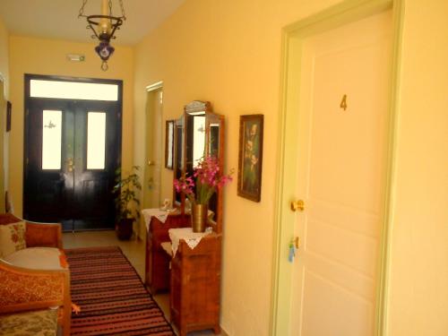 a hallway with a black door and a vase of flowers at Hariklia Rent Rooms in Zarós